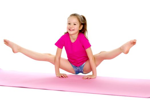A girl gymnast performs an acrobatic element on the floor. The concept of childhood, sport, healthy lifestyle. Isolated on white background.