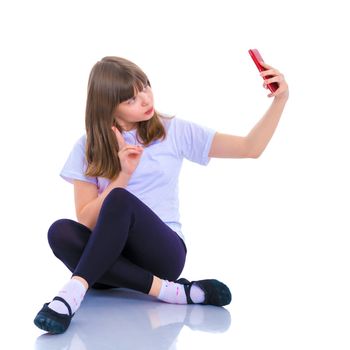 Happy smiling little girl making self-portrait on smartphone. The concept of people and technology. Isolated on white background.