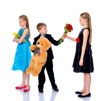 A little boy gives a little girl flowers. The concept of a happy childhood, love. Isolated on white background.