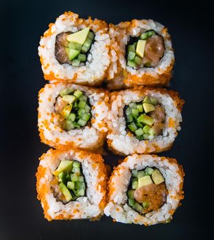 gorgeous sushi rolls over black background