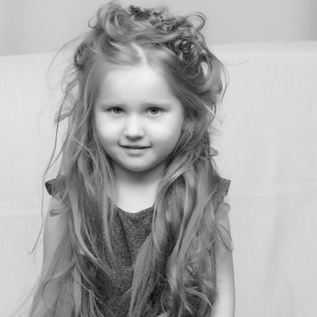 Portrait of a charming little girl close-up. The concept of happy people, childhood.Black and white, monochrome photo.