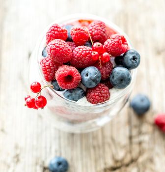 Dessert from yogurt with chia seeds, raspberries and blueberries on a old wooden background. top view