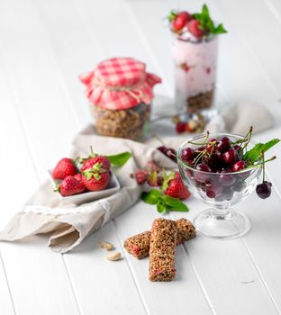 Tasty granola with nuts and yoghurt, berries on the side, healthy breakfast, sideview