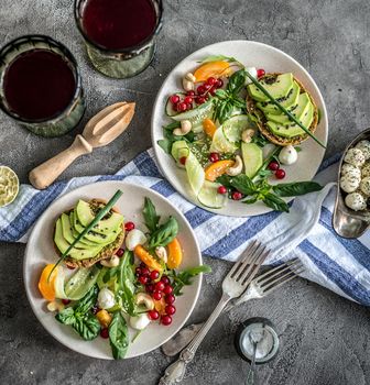 Vegetarian dinner - salad and wine on a dark background