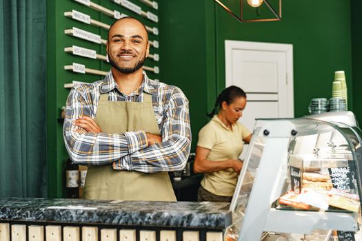 Portrait of a mixed race young man barista in coffee shop close up