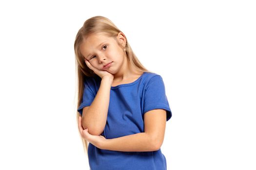 Portrait of adorable little girl isolated on a white background. in blue t-short with long white hair, sad, holding her head