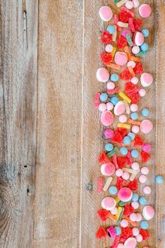 variety of candies on a wooden background with space for text