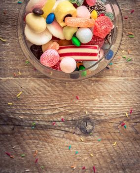 variety of candies on a wooden background with space for text