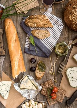 French food on a wooden background. Different types of cheese, wine and other ingredients on a wooden table