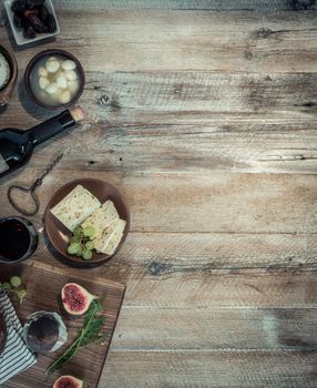 cheeses and brown bread on wooden table with text space