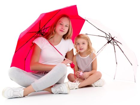 Lovely little girls hid under the umbrella. The concept of a happy childhood, family vacation. Isolated on white background.