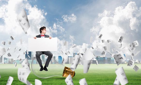 businessman with an empty banner. concept of creativity in business. around in the chaos flying paper