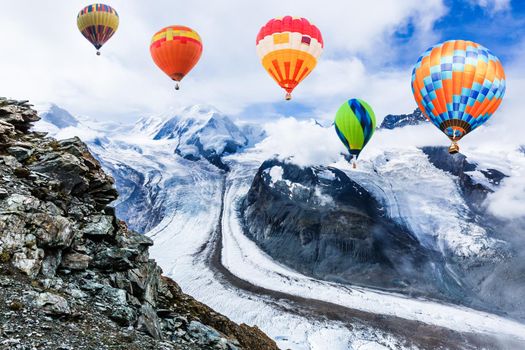 Colorful hot-air balloon flying over snowcapped mountain.