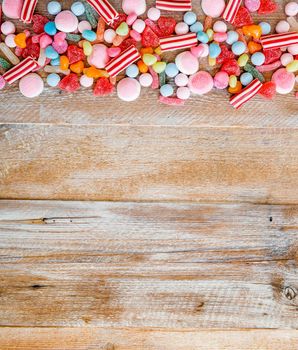 variety of candies on a wooden background with space for text