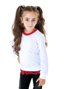 A beautiful little girl in an empty white T-shirt points to herself. The concept of design of T-shirts, advertising of children's goods. Isolated on white background.