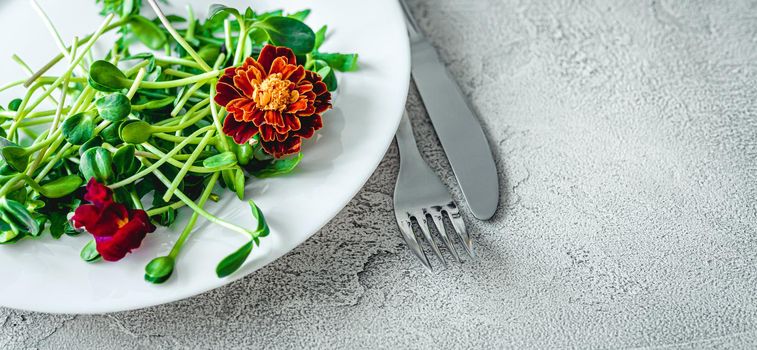 Fork and knife on round white plate with salad