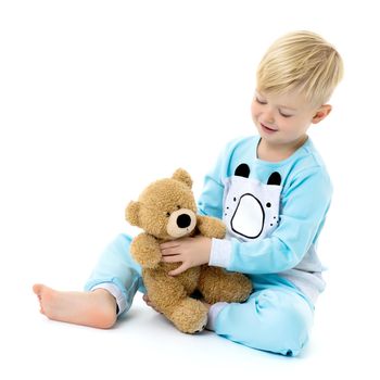 Cute little boy in pajamas with a teddy bear. The concept of family happiness. Isolated on white background.