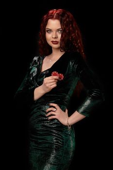 Young beautiful redheaded woman with chips in her hands over black. Win casino holdem poker slots