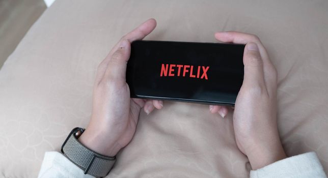 CHIANG MAI, THAILAND, NOV 17 , 2019: Woman hand holding Smart Phone with Netflix logo on Apple iPhone Xs. Netflix is a global provider of streaming movies and TV series..