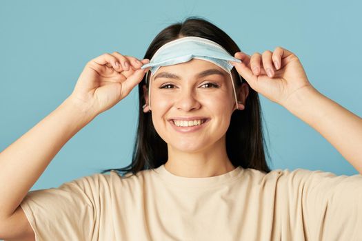 Happy woman posing and looking at camera while wearing protective face mask. Quarantine, coronavirus concept