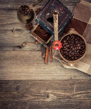 old grinder and coffee beans on a wooden background
