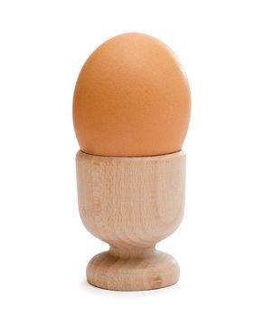 Brown egg in wooden cup isolated on white