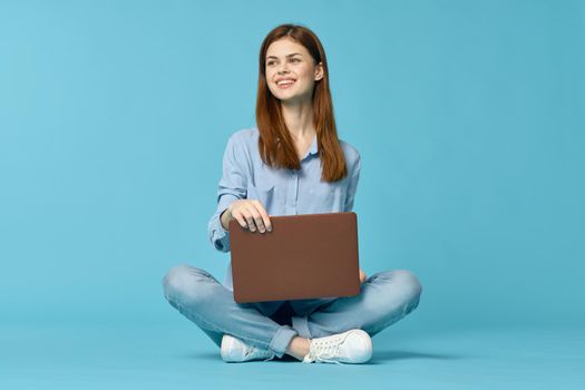 woman with laptop learning internet online education blue background. High quality photo