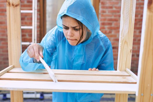 woman in protective suit painting wood renovation design. High quality photo