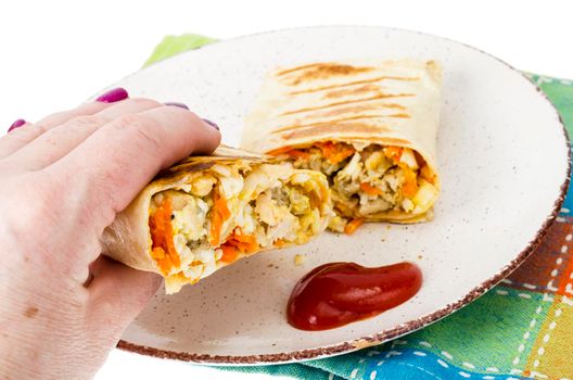 Hand holds piece of shawarma with meat. Studio Photo