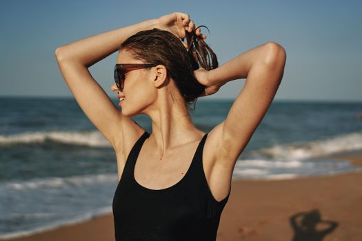 cheerful woman in black swimsuit sunglasses beach walk travel. High quality photo