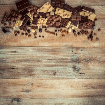 chocolate and candies on a wooden background with space for text