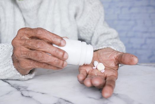 senior women hand's taking medicine, close up .