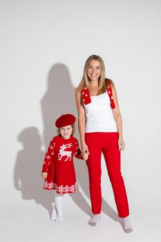 little girl in red dress and hat poses for the camera with her cheerful mother