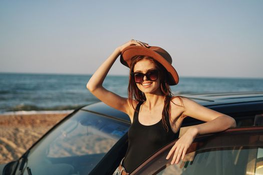 woman on the beach is with a car wearing sunglasses travel. High quality photo