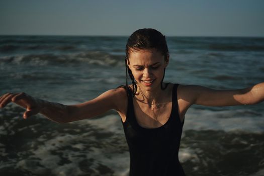 Cheerful woman black swimsuit ocean nature summer tan. High quality photo