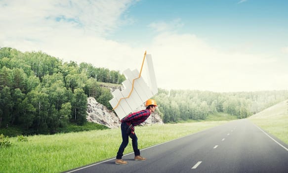 Young man builder carrying growing graph on his back
