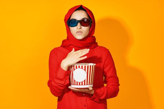 arab woman popcorn entertainment cinema yellow background. High quality photo