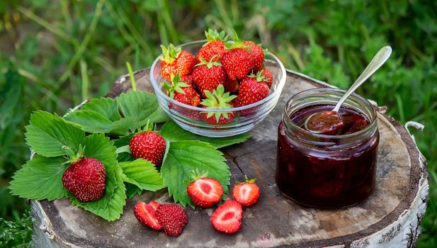 Strawberry jelly, jam on a wooden background, environmentally friendly product. Selective focus