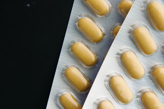 Close up of pills of blister pack on table .