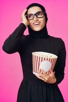Muslim woman entertainment cinema popcorn fashion purple background. High quality photo