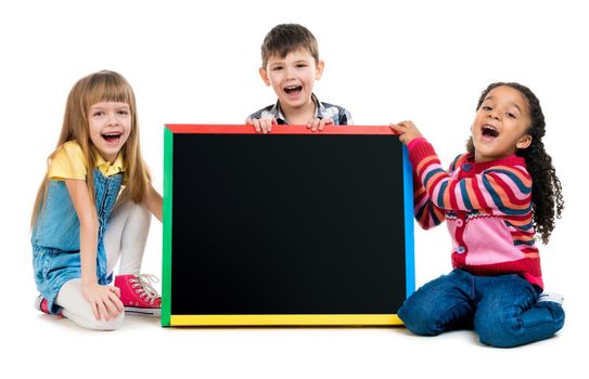 tree cheildren look at little blackboard sitting on the floor isolated on white background