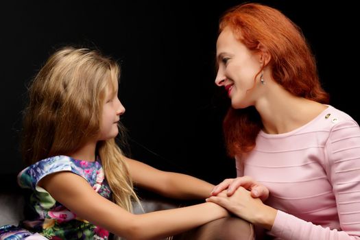 Young mother and little daughter gently embrace. The concept of Happy Childhood, Family Happiness, Raising a Child.