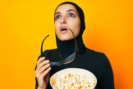 arab woman in black hijab popcorn 3D glasses cinema ethnicity model. High quality photo