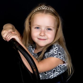 Beautiful little girl on a black background. Studio photography