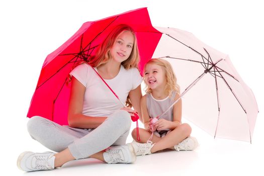 Lovely little girls hid under the umbrella. The concept of a happy childhood, family vacation. Isolated on white background.