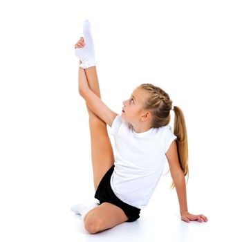 A sweet little girl shows gymnastic exercises that she learned at a sports school. The concept of sport and fitness. Isolated on white background.