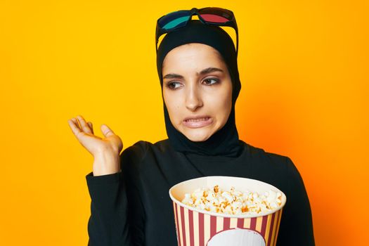 cheerful woman in black hijab popcorn 3D glasses cinema ethnicity model. High quality photo
