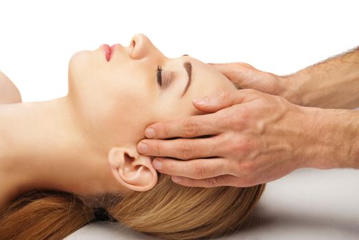 Young bright woman receiving a head massage in a spa centre