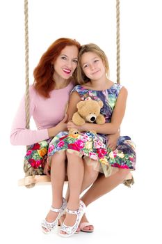 Happy mom and daughter swing on a swing. The concept of family happiness, parenting. Isolated on white background.