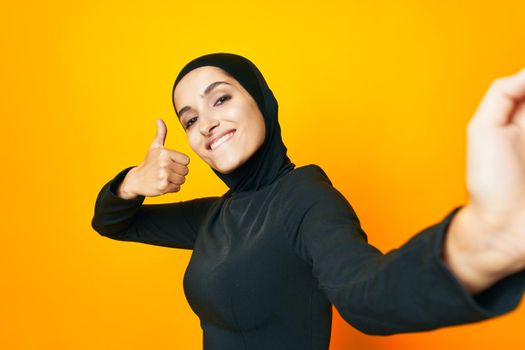 Muslim in black hijab posing fashion hand gesture isolated background. High quality photo